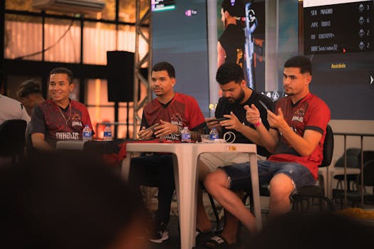 A group of e-sports players participating in a gaming event, focused on smartphone gameplay.