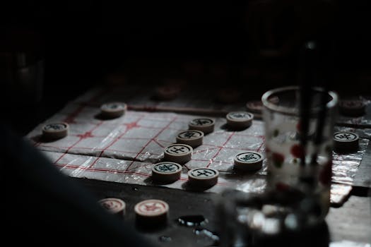 Close-up of a Chinese chess game in dark ambiance with selective focus on pieces.