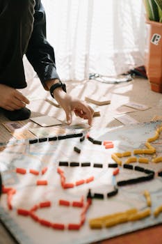 Close-up of a person playing a strategy board game, capturing a fun indoor leisure time activity.
