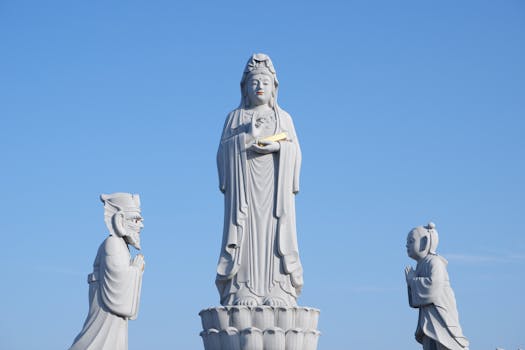 Elegant statues of Kwan Im under a clear blue sky in South Korea.