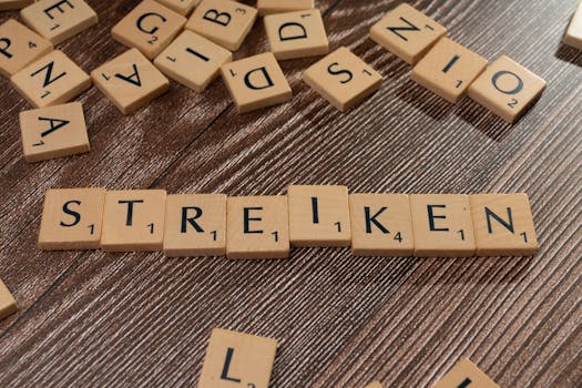 Wooden Scrabble tiles forming the word 'STREIKEN' on a textured surface, indicating a strike theme.
