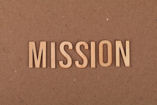 Wooden letters spelling 'MISSION' on textured cardboard background, emphasizing goals and purpose.